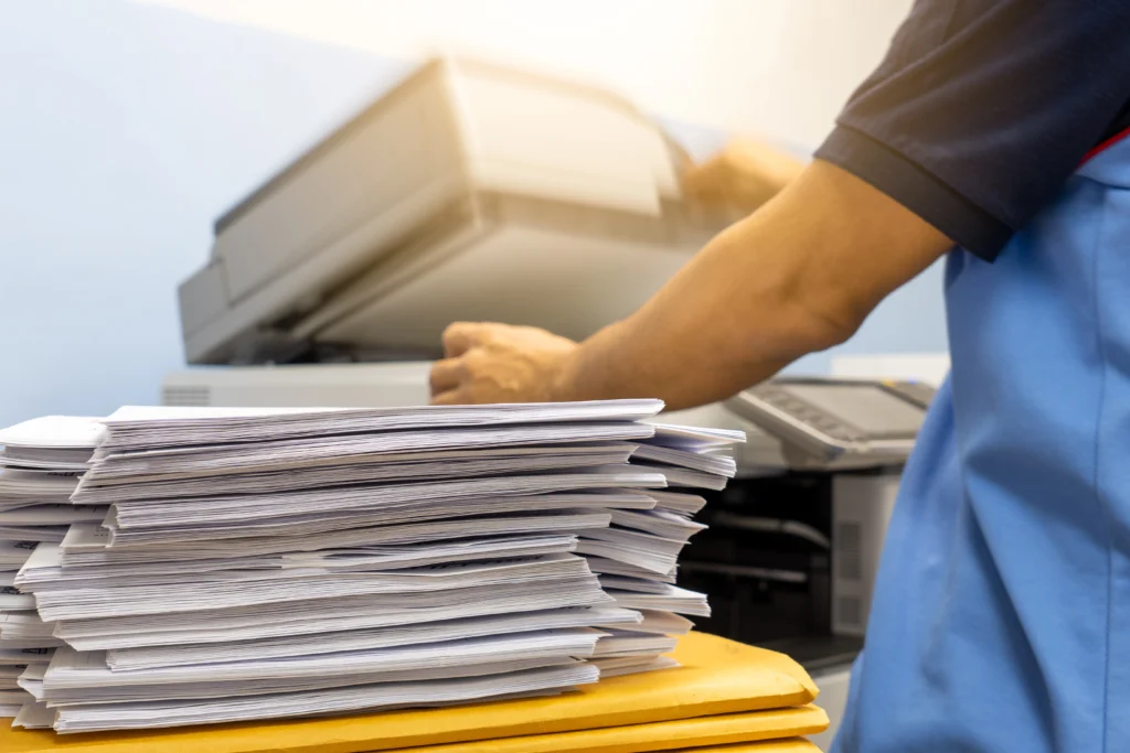 Stack of papers next to a copier ready for faxing
