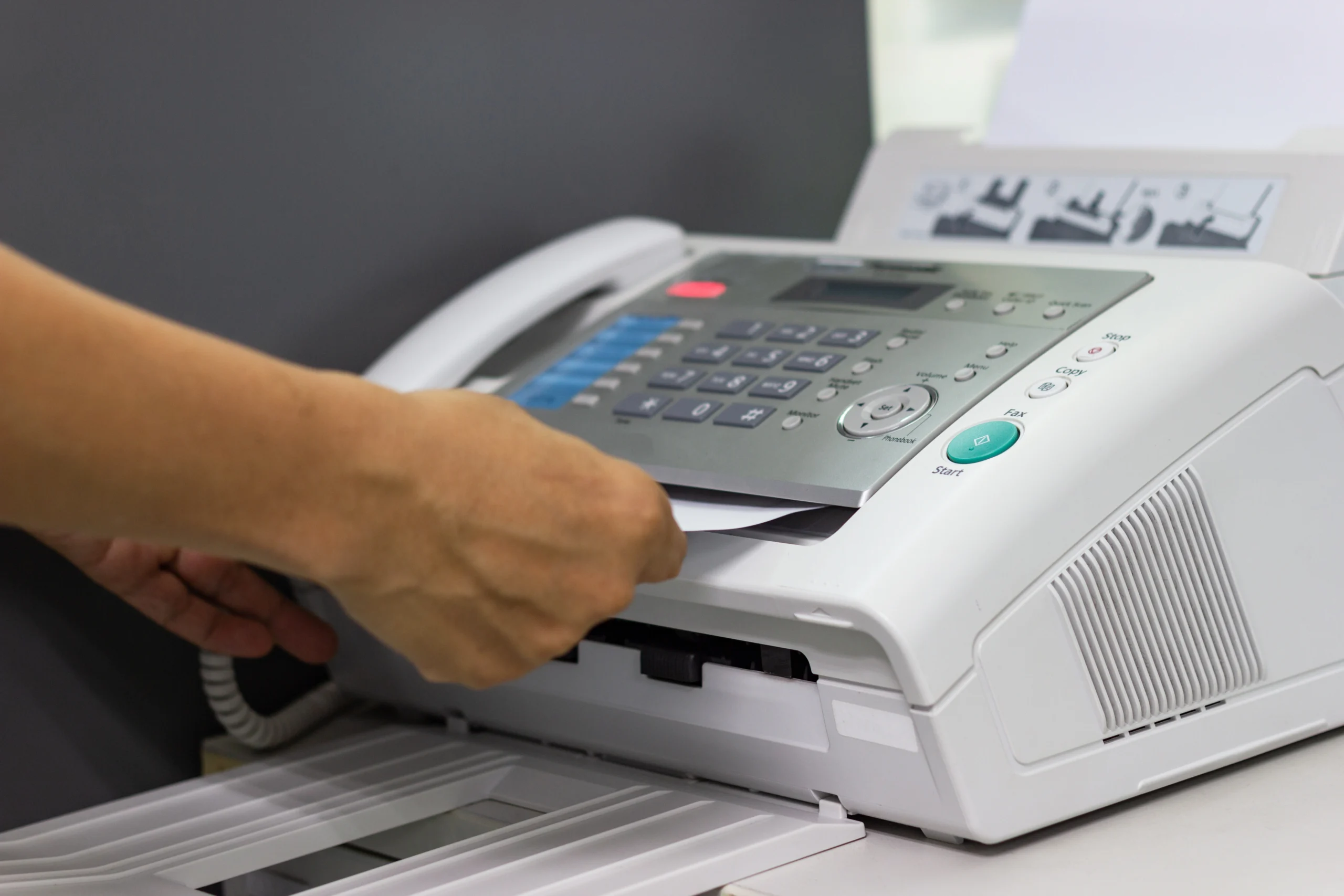 Hand of man are using a fax machine in the office