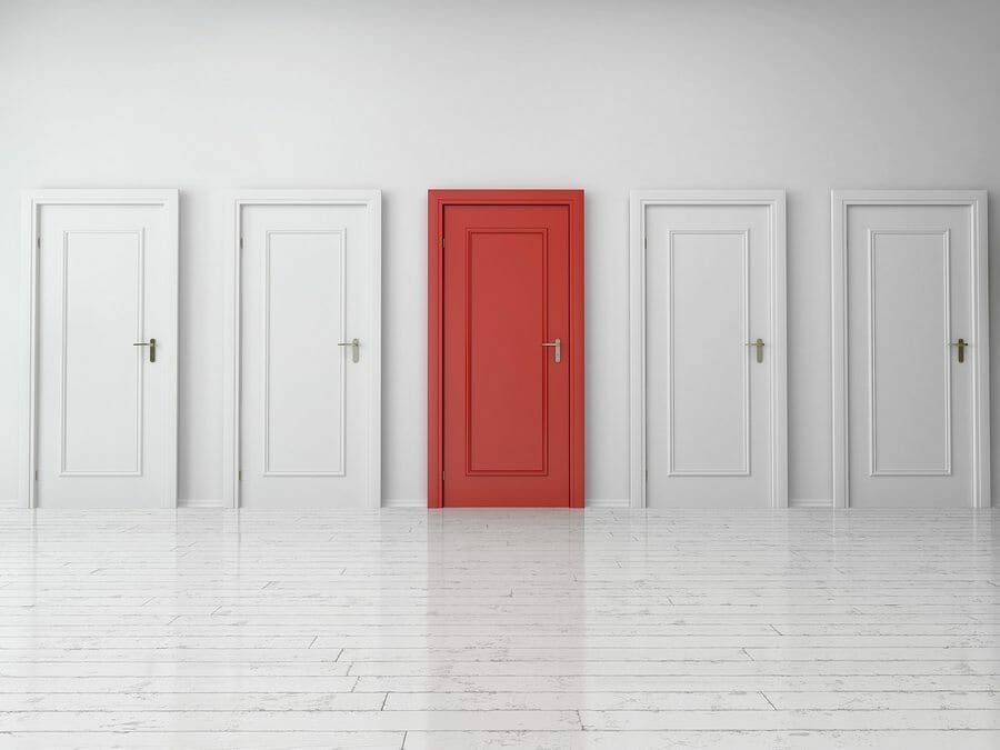 3d Rendering of Five Similar Style Single Doors, One is Red and Four are White, on Plain Wall Inside an Empty Building.